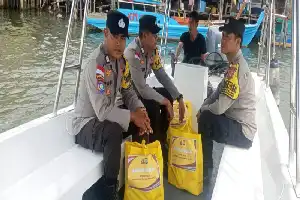 Ayudando a las víctimas del desastre de vientos fuertes, la policía de Gunung Kijang distribuye paquetes de alimentos básicos